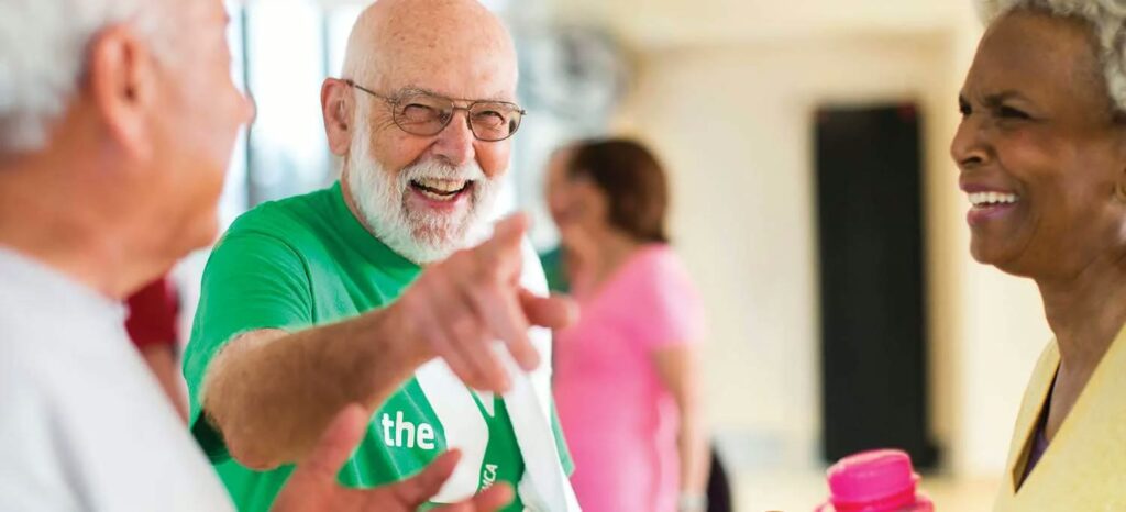 A smiling YMCA member enjoying a conversation with other members