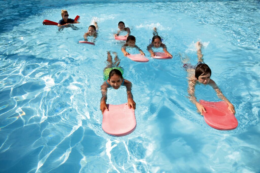 Children paddling in the water with boogie boards